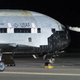 This image provided by Vandenberg Air Force Base shows technicians examining the X-37B unmanned spaceplane shortly after landing Friday Dec. 3, 2010 at Vandenberg Air Force Base, Calif. The X-37B slipped out of orbit and landed after a successful maiden flight that lasted more than seven months, the Air Force said.
